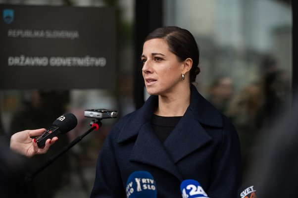 Ana Kerševan pred mikrofoni, pred vhodom v stavbo Državnega odvetništva